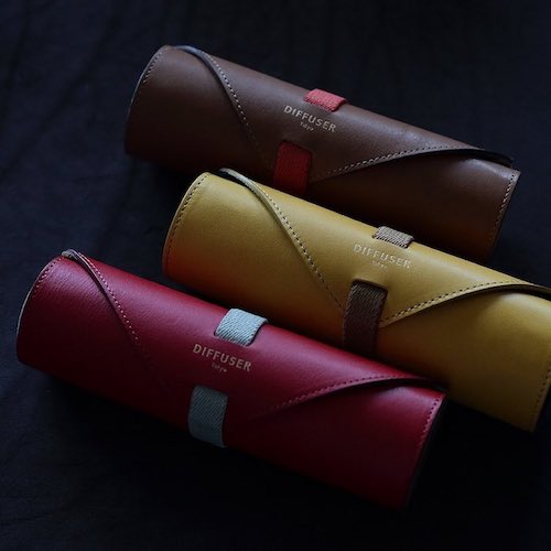 Three Diffuser Tokyo leather roll glasses cases, in brown, yellow, and red